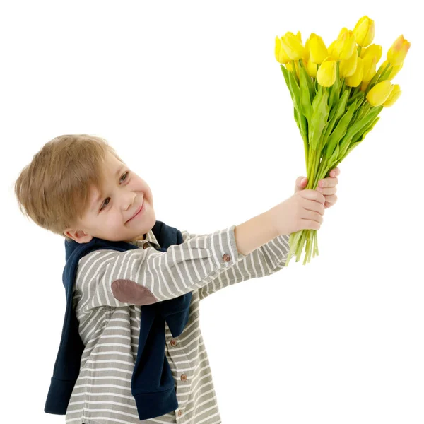 Niño pequeño con un ramo de flores tulipanes . — Foto de Stock