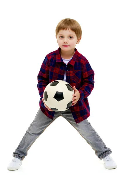 Menino está jogando com uma bola de futebol . — Fotografia de Stock