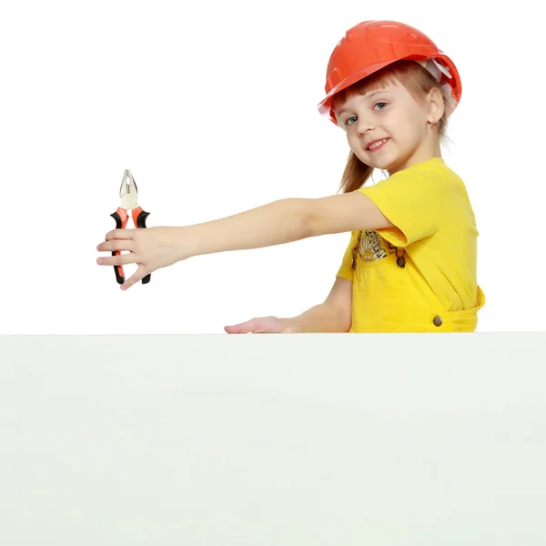 Mädchen mit Bauhelm guckt hinter einer Werbetafel hervor. — Stockfoto