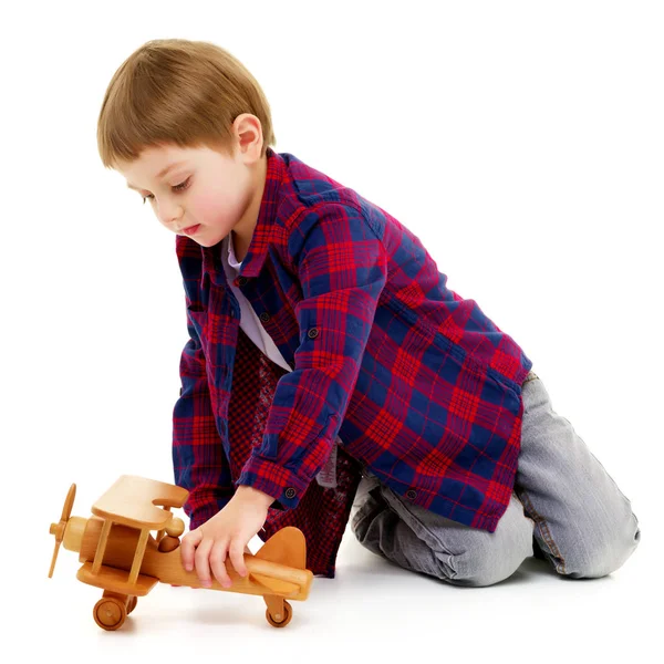 Menino brincando com avião de madeira — Fotografia de Stock