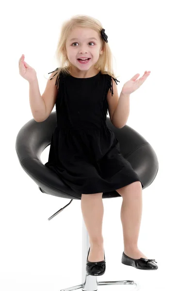 Klein meisje zit op een stoel — Stockfoto
