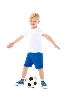 Küçük çocuk bir futbol topuyla oynuyor.