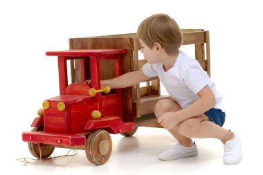 Küçük çocuk bir ahşap araba ile oynuyor.