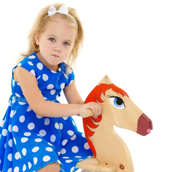 Menina balançando em um cavalo de madeira . — Fotografia de Stock