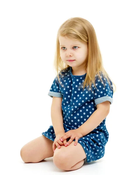 Het kleine meisje zit op haar knieën.. — Stockfoto