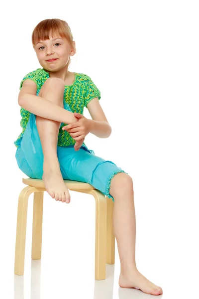 La niña está sentada en una silla. — Foto de Stock