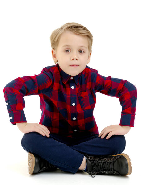 маленький мальчик сидит на полу
