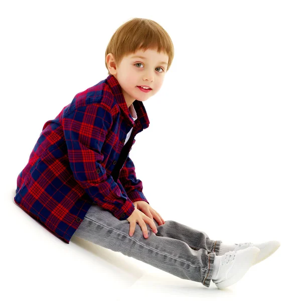 Niño pequeño está sentado en el suelo — Foto de Stock