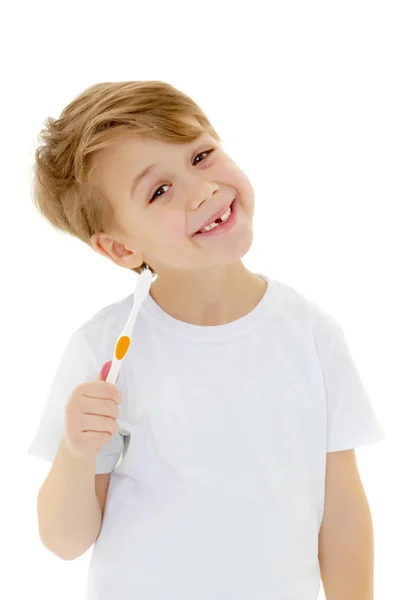 Un niño se cepilla los dientes con un cepillo de dientes.. —  Fotos de Stock