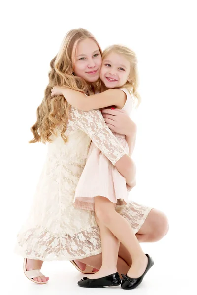 Una joven abraza a su hermana pequeña. — Foto de Stock
