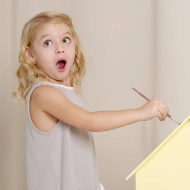 Neşeli küçük kız bir fırça çekiyor.