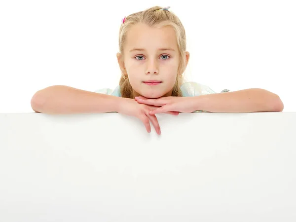 Uma menina está olhando por trás de uma bandeira vazia. — Fotografia de Stock