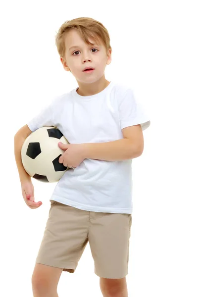 Ein kleiner Junge in einem reinweißen T-Shirt spielt mit einem Soccerspiel — Stockfoto