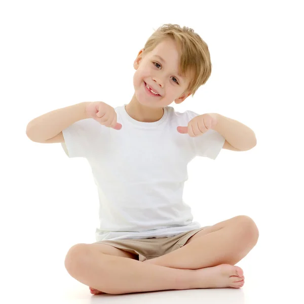 Um menino em uma camiseta branca pura aponta os dedos para ela . — Fotografia de Stock