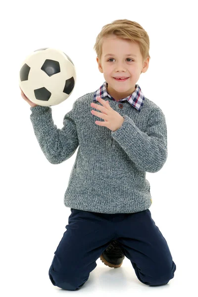 Menino está jogando com uma bola de futebol . — Fotografia de Stock