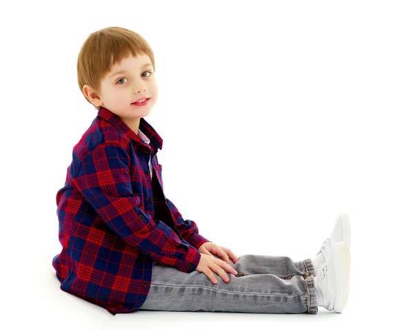 Niño pequeño está sentado en el suelo — Foto de Stock