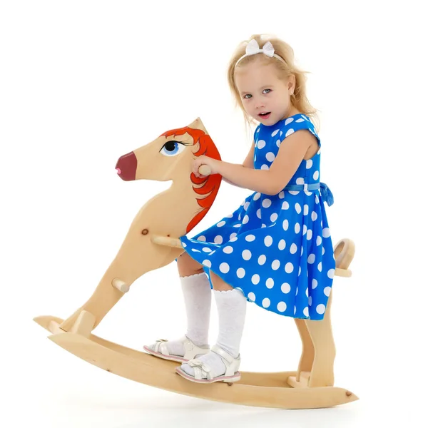 Meisje swingen op een houten paard. — Stockfoto