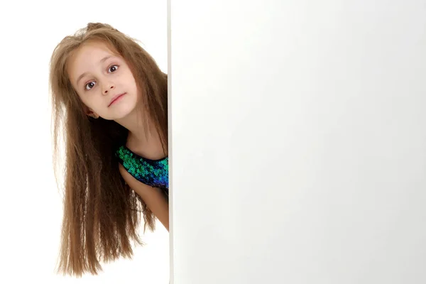 Una niña está mirando detrás de una pancarta vacía.. — Foto de Stock