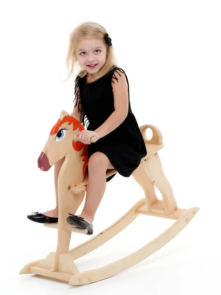 Chica balanceándose en un caballo de madera . —  Fotos de Stock