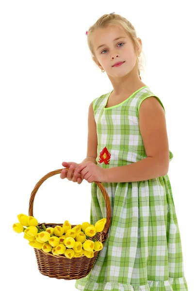 Niedliches kleines Mädchen mit einem Korb voller Blumen. — Stockfoto