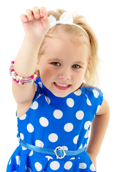 En liten flicka sätter ett armband på armen. — Stockfoto