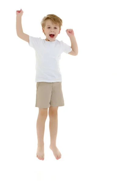 Temiz beyaz bir tişört içinde küçük bir çocuk eğlence atlama. — Stok fotoğraf