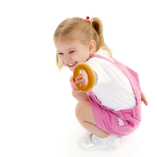 Küçük kız bir simit yemek — Stok fotoğraf
