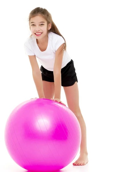 Niña haciendo ejercicios en una pelota grande para la aptitud. — Foto de Stock