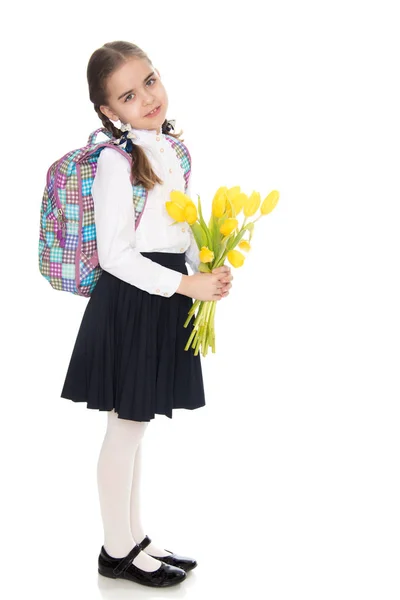 Uma estudante com um buquê de flores e uma mochila em seu sho — Fotografia de Stock