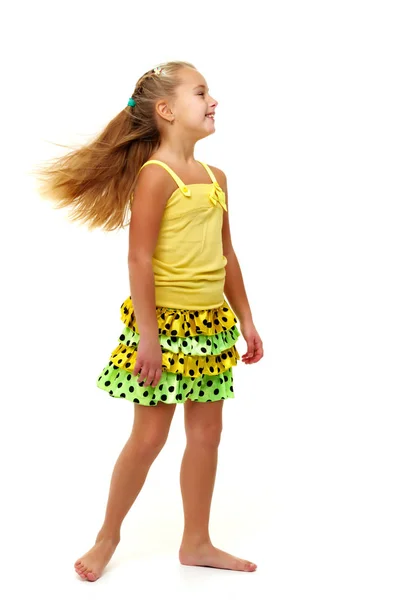 Liten flicka i en klänning som utvecklas i vinden. — Stockfoto