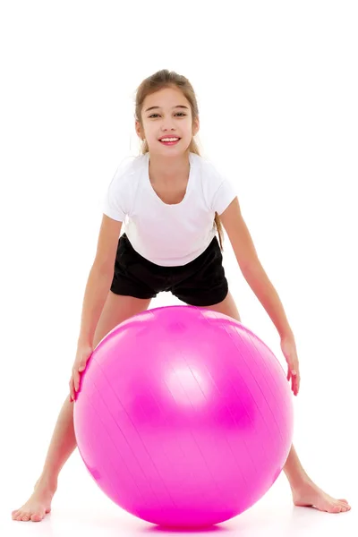 Niña haciendo ejercicios en una pelota grande para la aptitud. — Foto de Stock