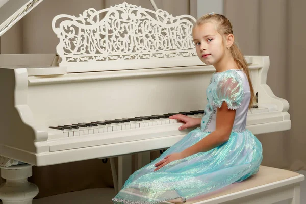 Dívka je u bílého klavíru.. — Stock fotografie