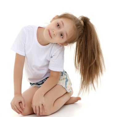 Küçük kız yerde oturuyor..