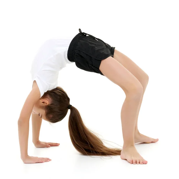 The little gymnast performs a bridge. — Stock Photo, Image