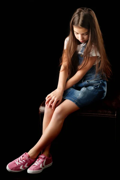 Μικρό κορίτσι με τζιν ρούχα σε μαύρο φόντο. — Φωτογραφία Αρχείου