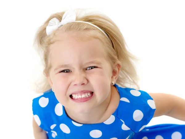 Een klein meisje pronkt met haar schone, zelfs tanden. — Stockfoto