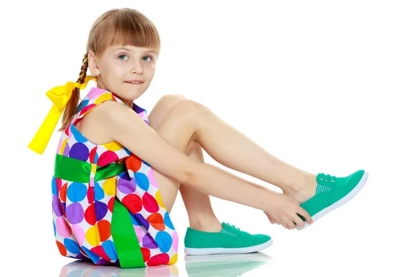 Una niña en un vestido con un patrón de circl multicolor —  Fotos de Stock