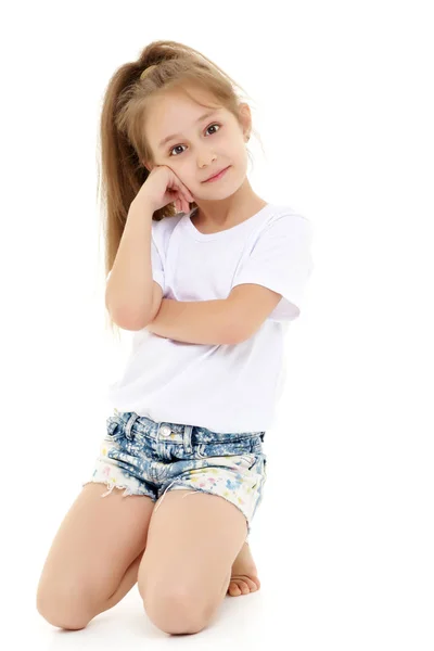 Klein meisje in een zuivere witte t-shirt voor reclame en shorts. — Stockfoto