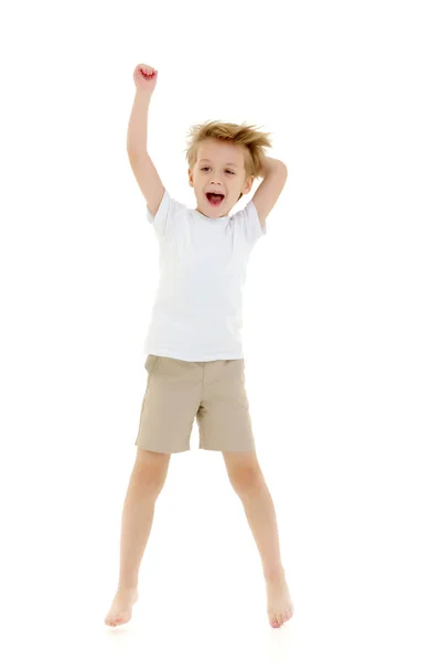 Un petit garçon dans un t-shirt blanc propre saute d'amusement . — Photo