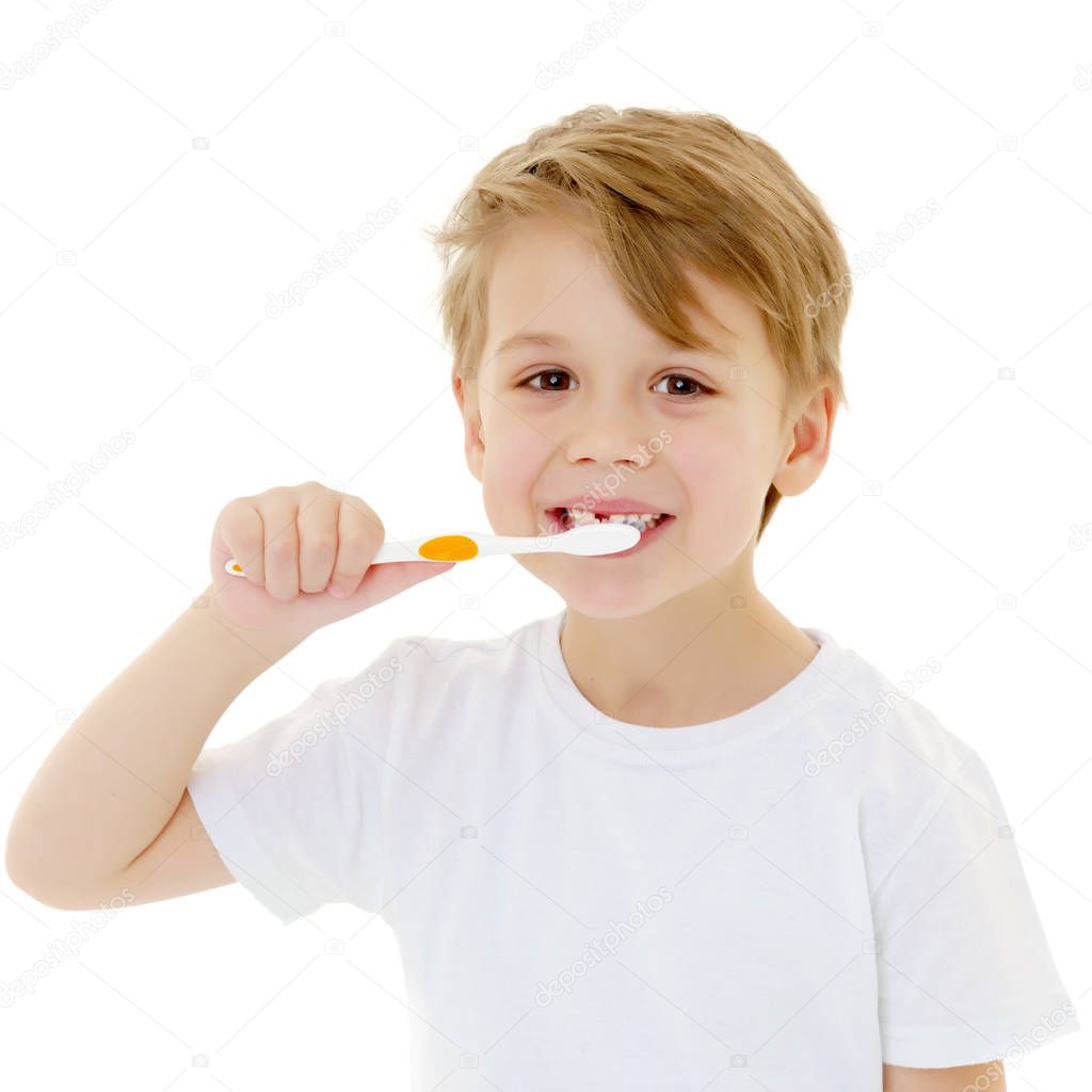 A little boy is brushing his teeth with a toothbrush.