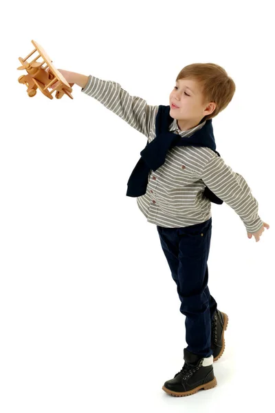 Мальчик играет с деревянным самолетом — стоковое фото