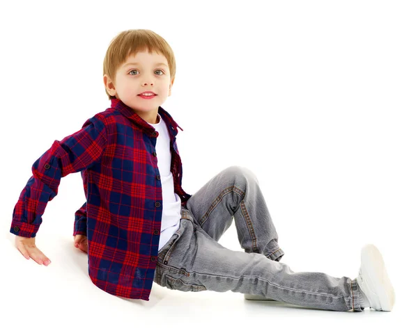 Niño pequeño está sentado en el suelo —  Fotos de Stock