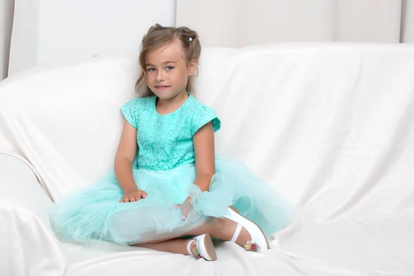 Little girl is sitting on the couch — Stock Photo, Image