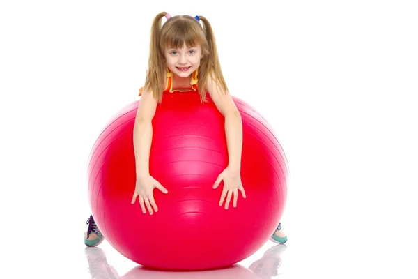 Niña haciendo ejercicios en una pelota grande para la aptitud. — Foto de Stock