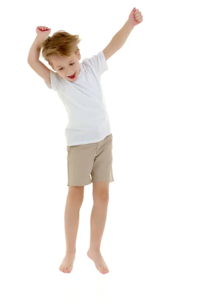 A little boy in a clean white T-shirt is jumping fun. Royalty Free Stock Images