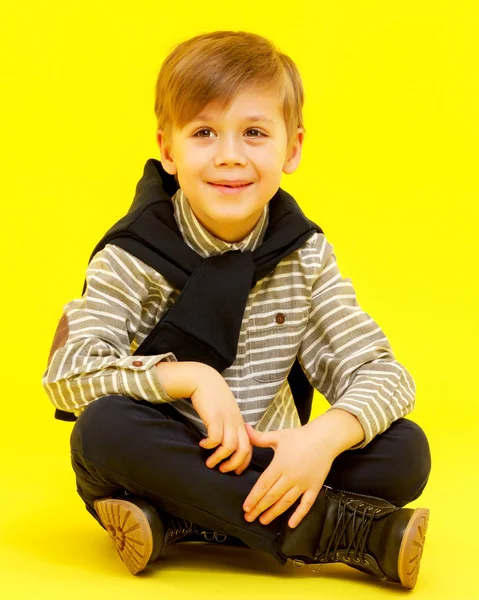 O menino está sentado no chão. . — Fotografia de Stock