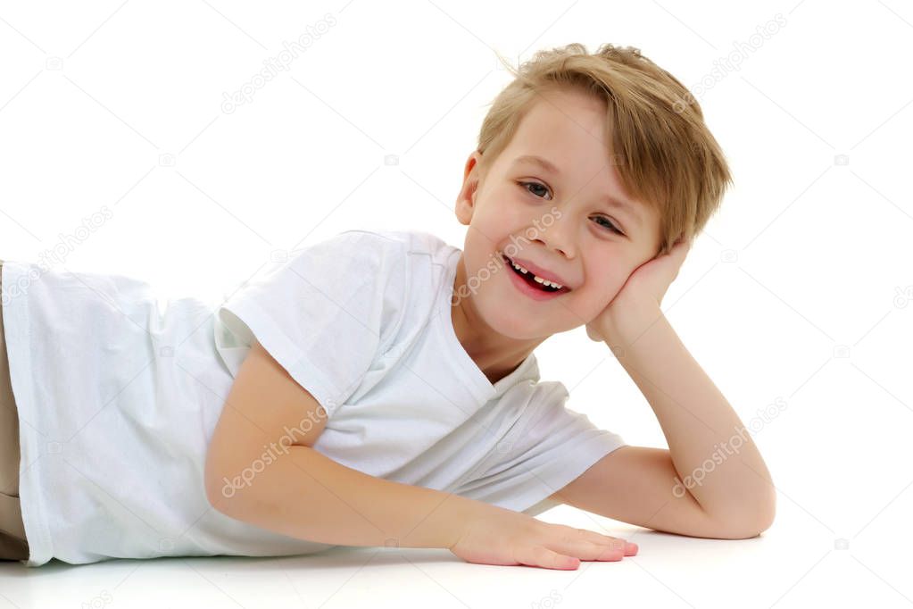 A little boy in a pure white t-shirt laughs. Emotions.