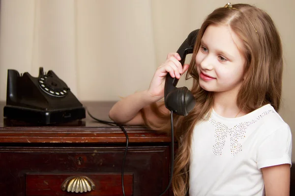 Seorang gadis kecil berdering di telepon lama. — Stok Foto