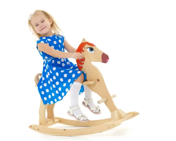 Chica balanceándose en un caballo de madera . —  Fotos de Stock