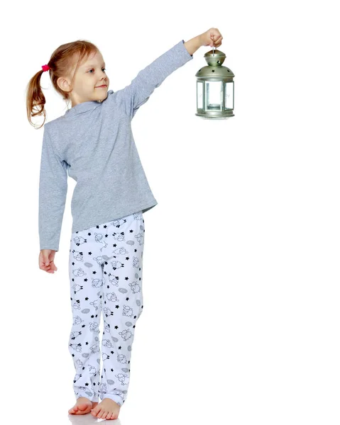 Una niña está sosteniendo una lámpara . — Foto de Stock
